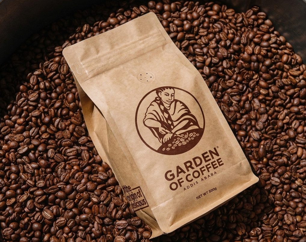 Garden of Coffee kraft bag resting on roasted beans